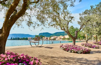 Idyllisk strandpromenade langs Gardasøen i Bardolino med turkisblåt vand, smukke strande og mediterrant landskab
