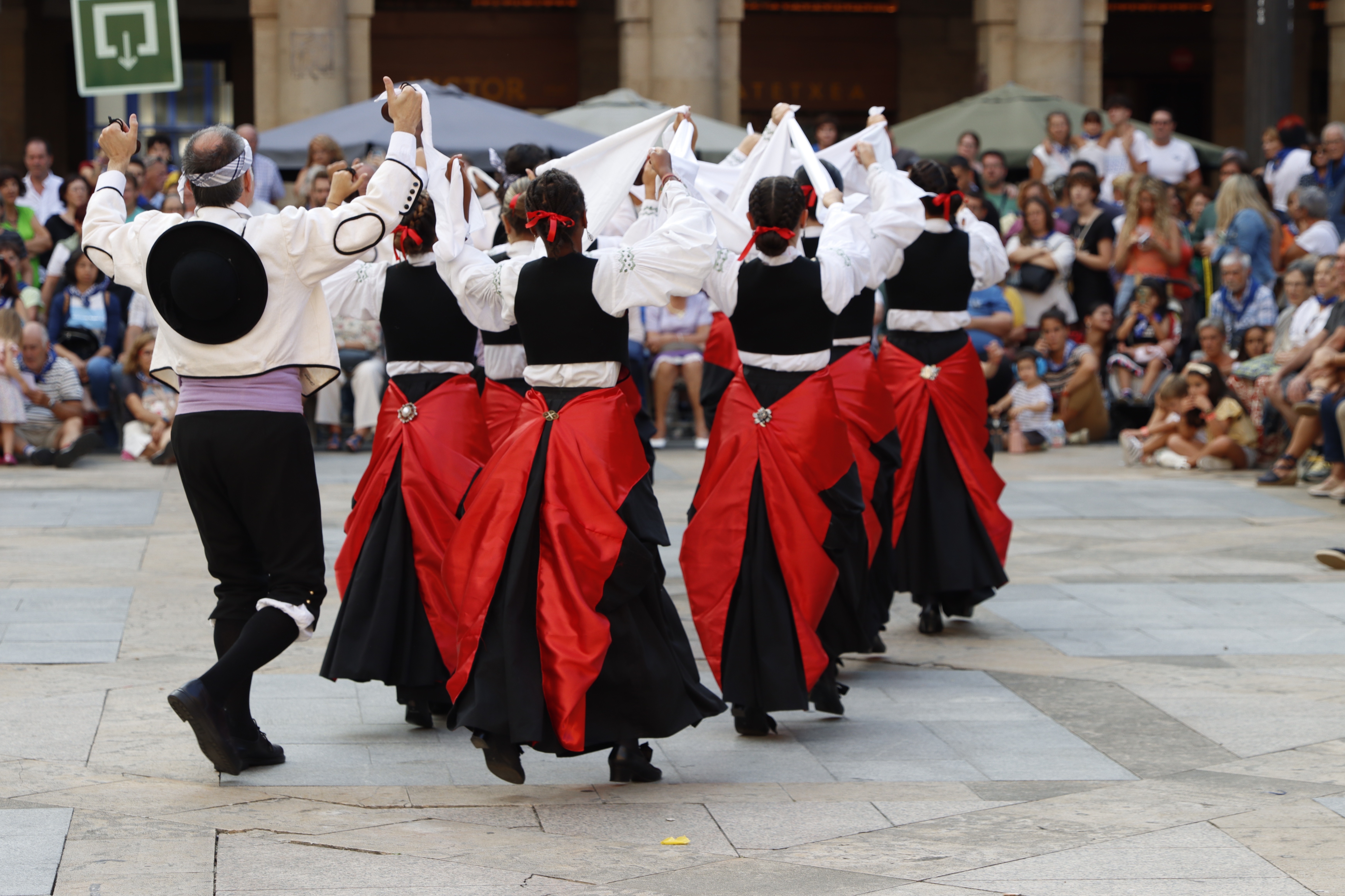 Traditionel baskisk folkedans med dansere i farverige røde og sorte dragter under en kulturfestival i Bilbao, Spanien