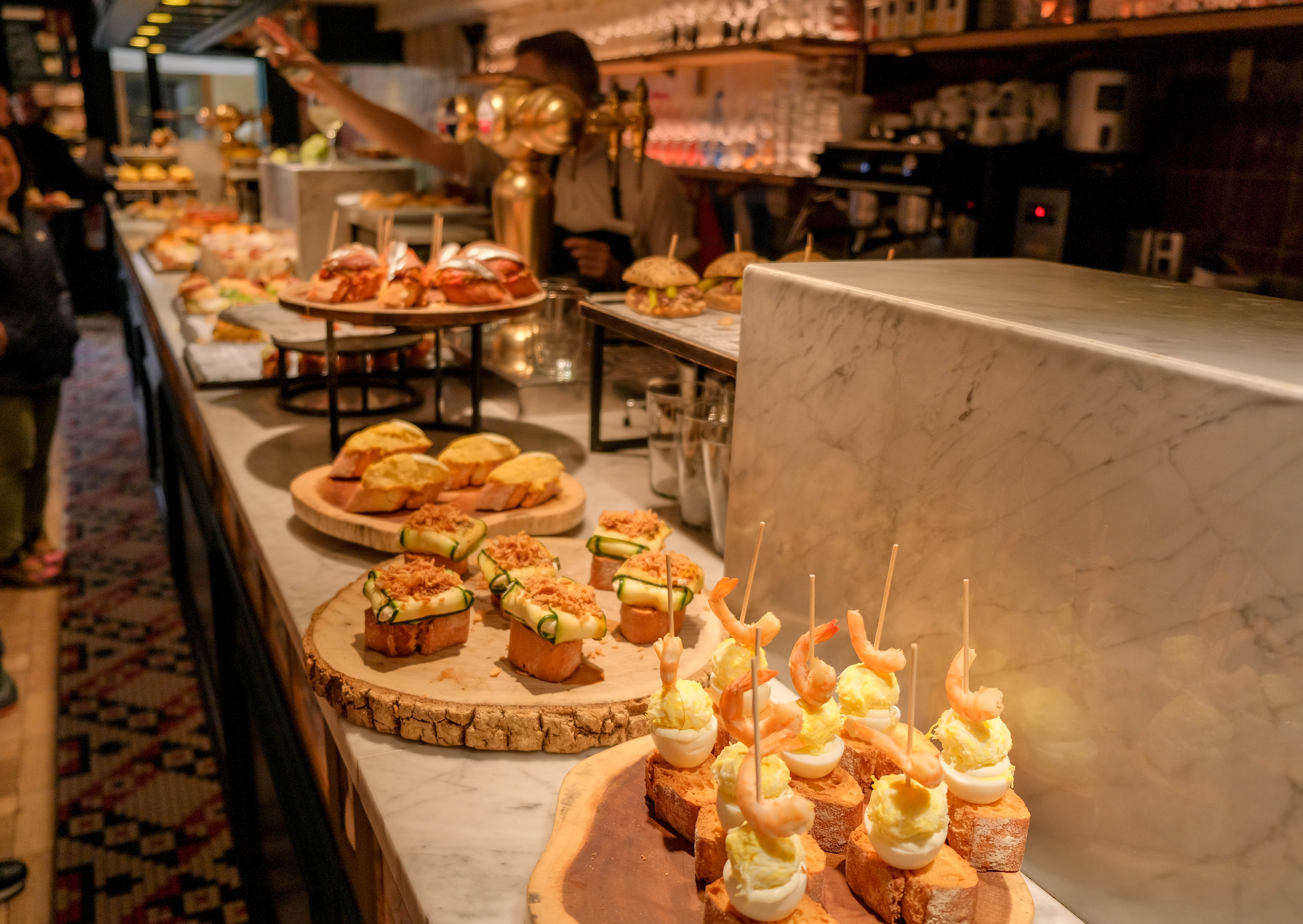 Farverige baskiske pintxos på en bardisk i Bilbao - de traditionelle små tapas-retter er en gastronomisk oplevelse under frokostpausen på vores solformørkelsesrejse til Baskerlandet