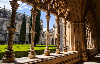 Smukke stensøjler og buer i klostergangen ved Batalha-klosteret i Portugal med karakteristisk sengotisk og Manueline arkitektur