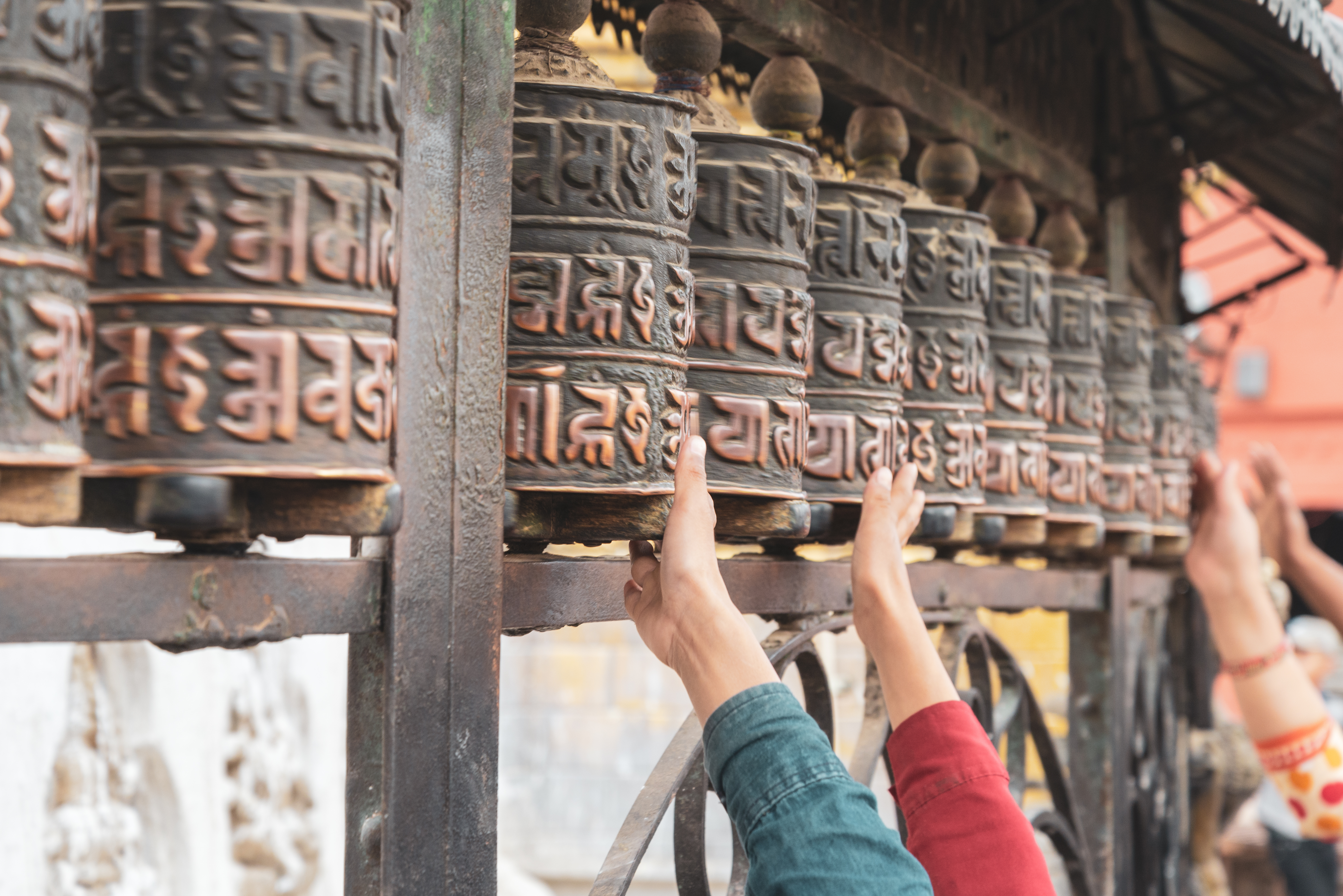 Pilgrimme drejer traditionelle tibetanske bedemøller ved Swayambhunath tempel i Nepal