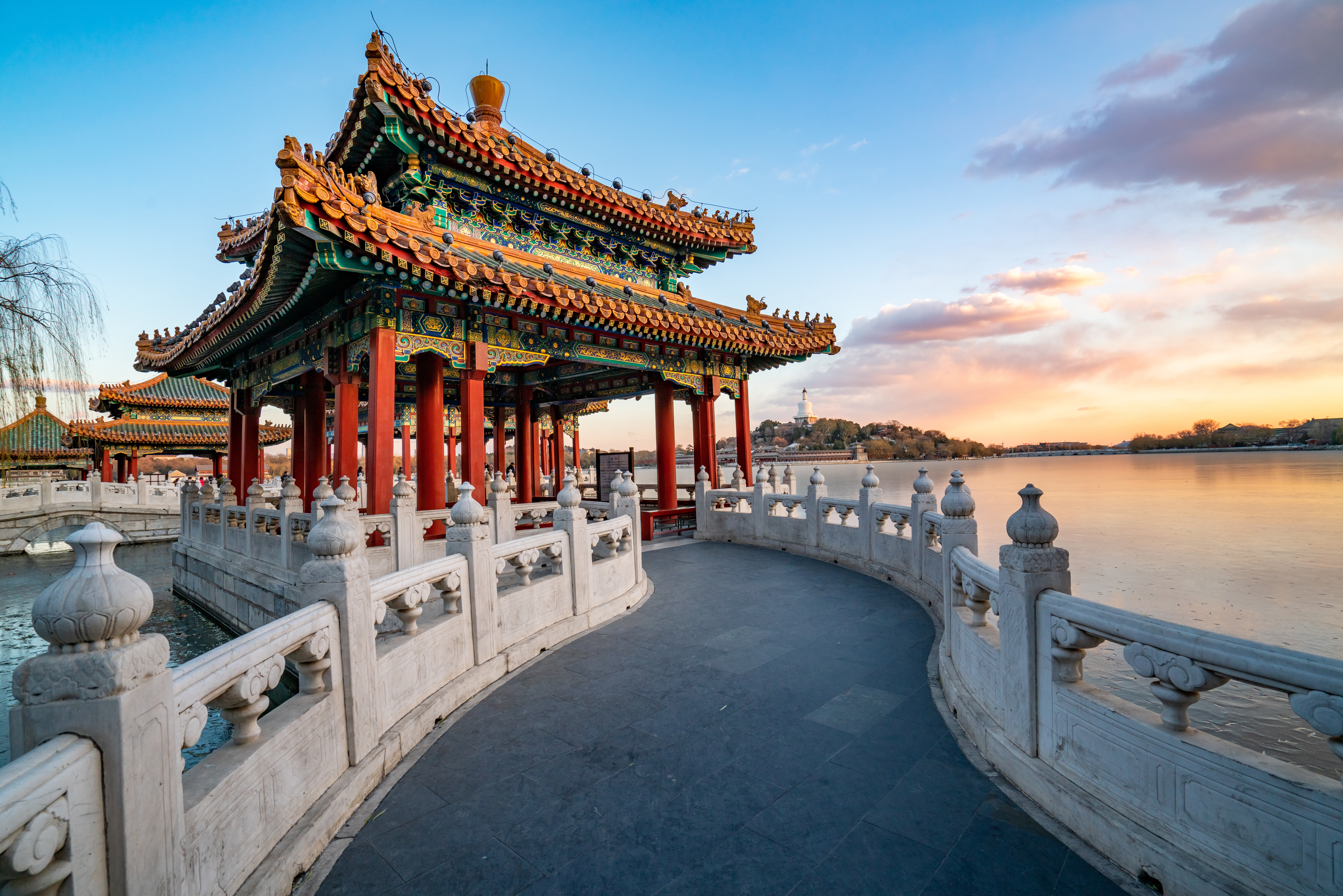 Traditionel kinesisk pavillon i Beihai Park Beijing ved solnedgang over søen