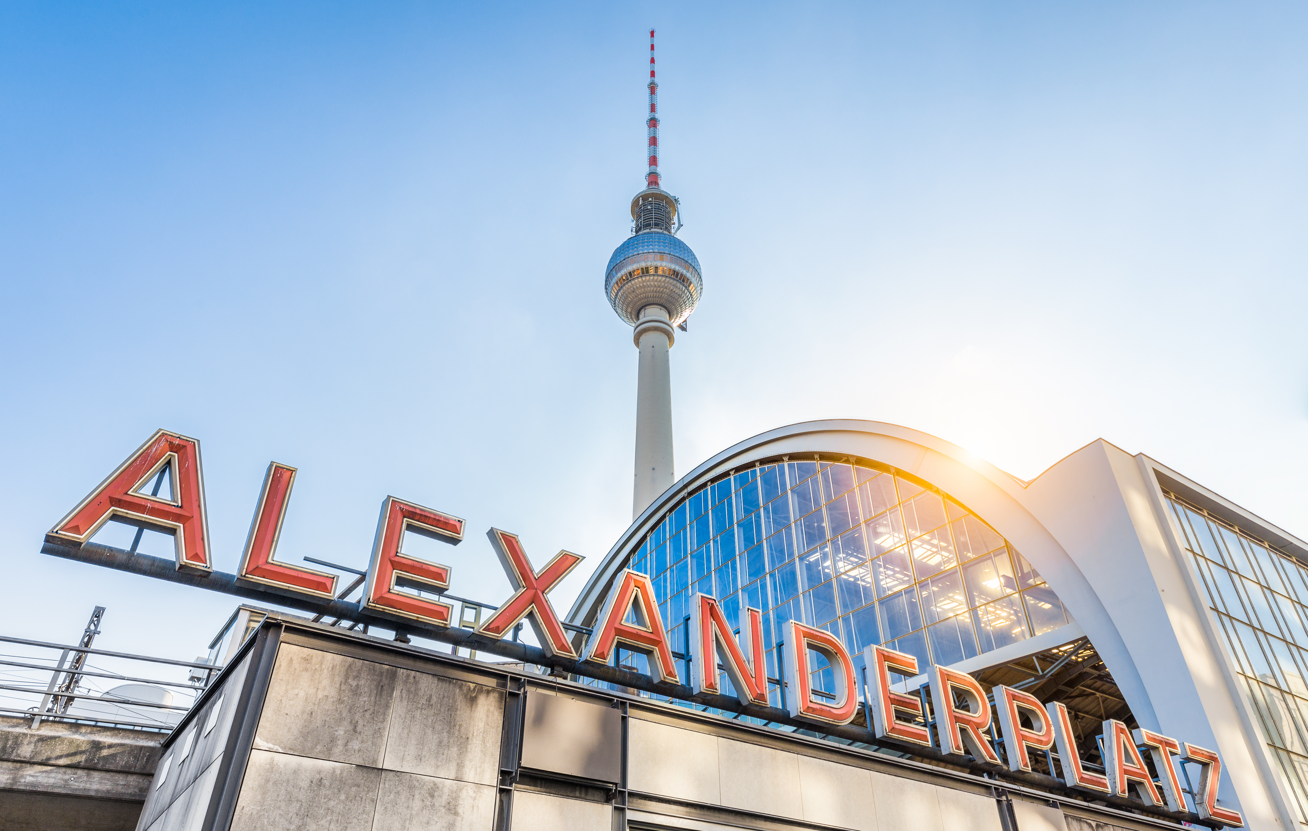 Berlin TV-tårn og Alexanderplatz station ved solnedgang med blå himmel