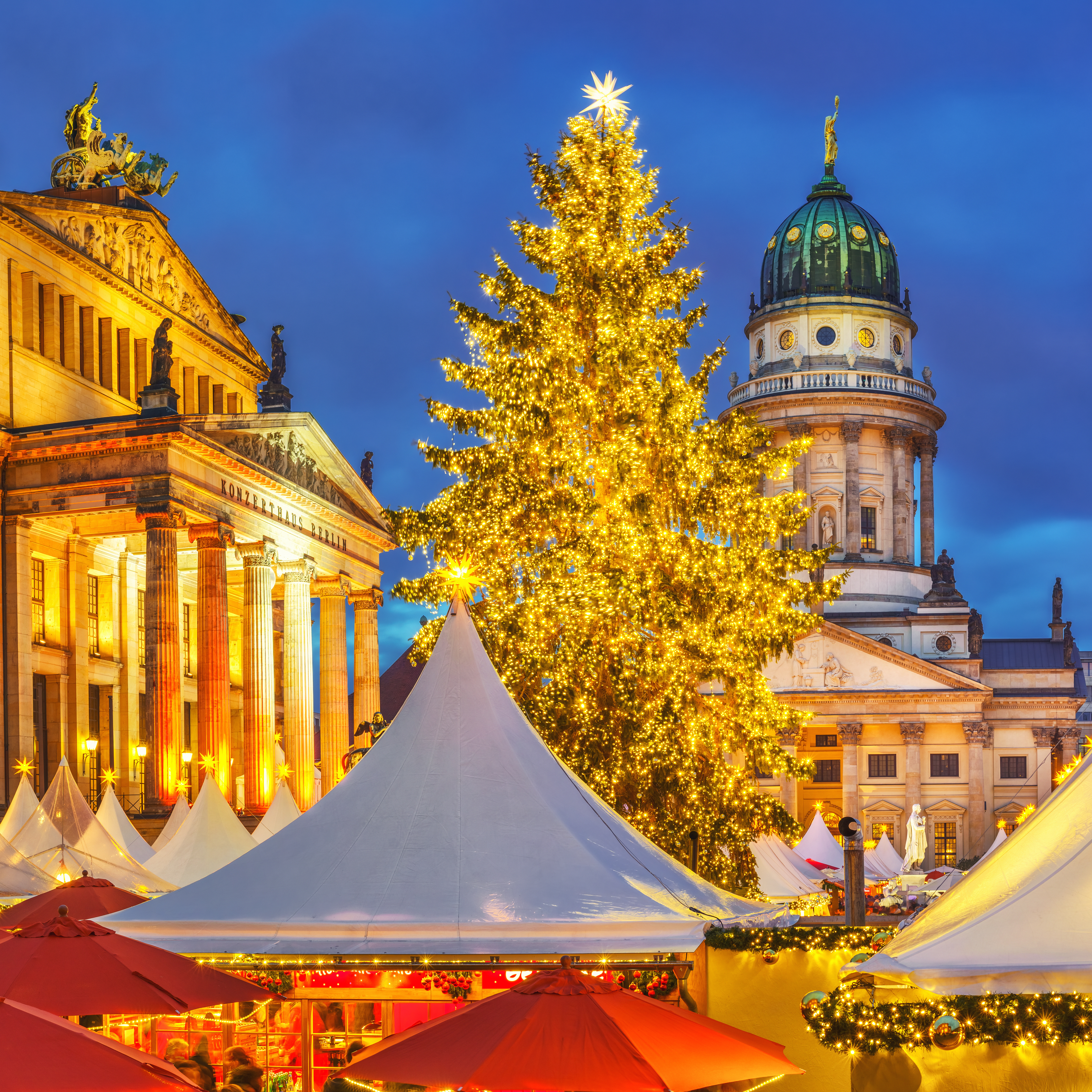 Berlin julemarked på Gendarmenmarkt med oplyst katedral og juletræ om aftenen