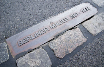Berliner Mur mindesten i brolægget viser historiske datoer 1961-1989 i Berlin