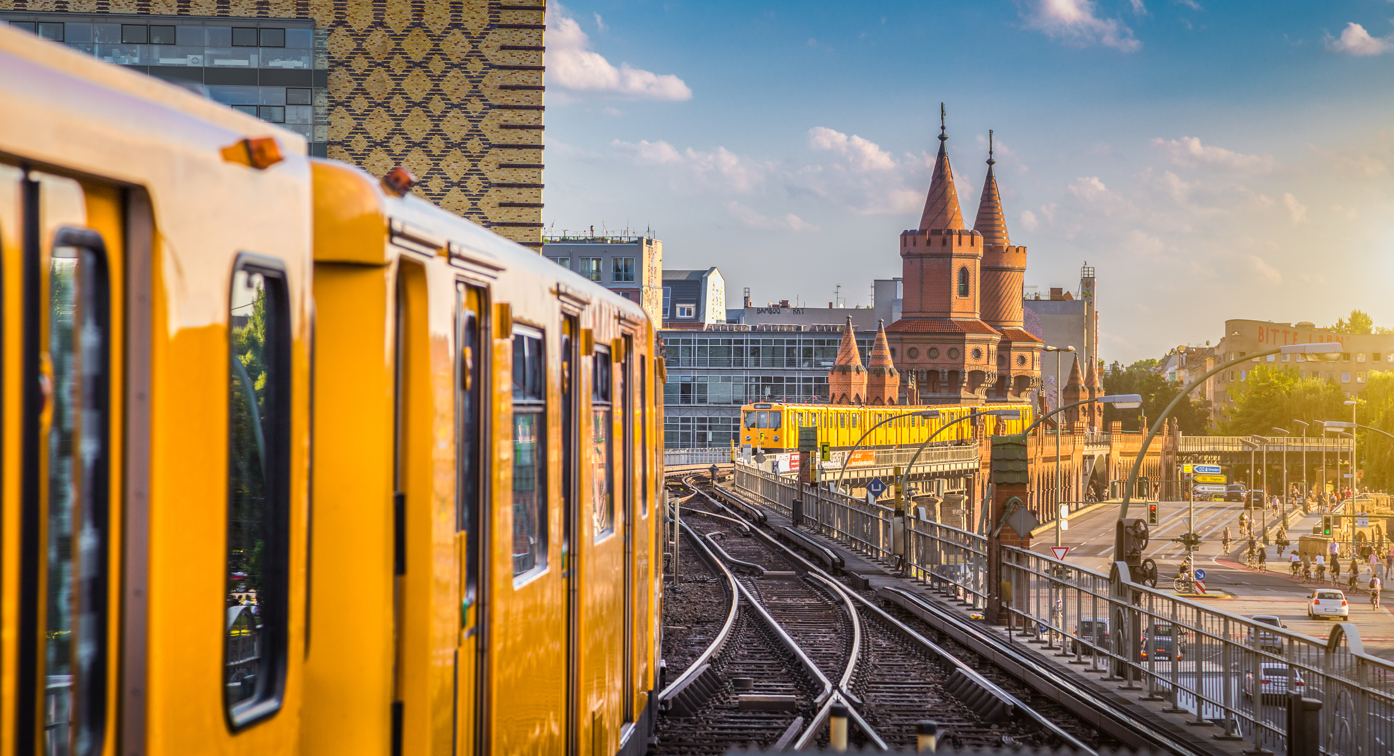 Gult U-Bahn tog ved Oberbaum Broen i Berlin under solnedgang
