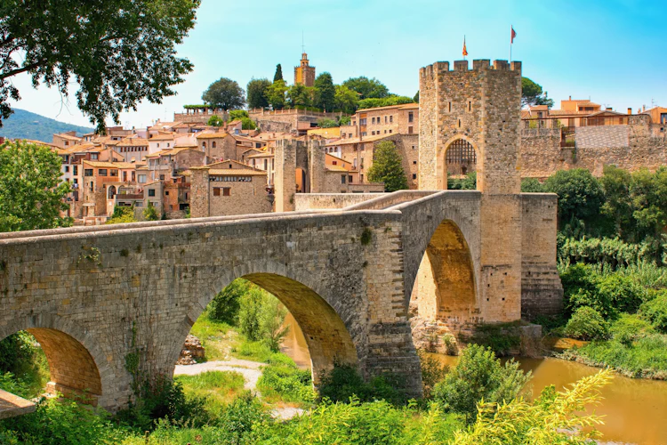 Historisk middelalderlig stenbro med befæstet port over Fluvia-floden i den charmerende landsby Besalú i Girona-provinsen, Katalonien
