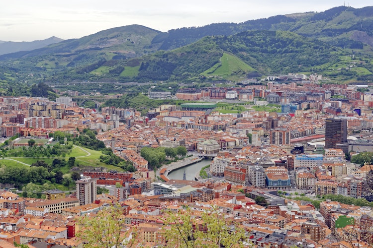 Panoramaudsigt over Bilbaos bycentrum fra Artxanda-bjerget med arkitektur, Nervion-floden og skyline under skyet himmel i Nordspanien