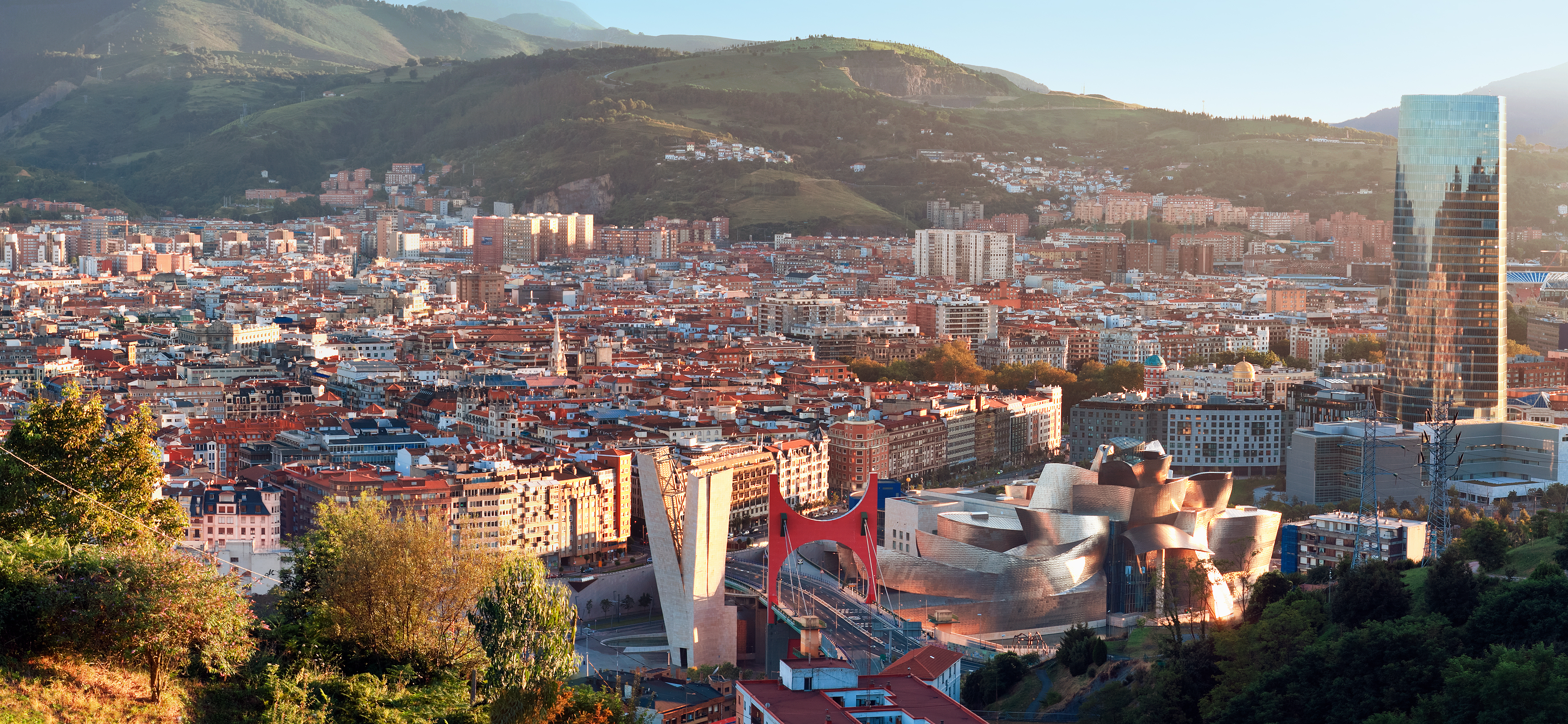 Panoramaudsigt over Bilbao by med Guggenheim Museum og baskiske bjerge