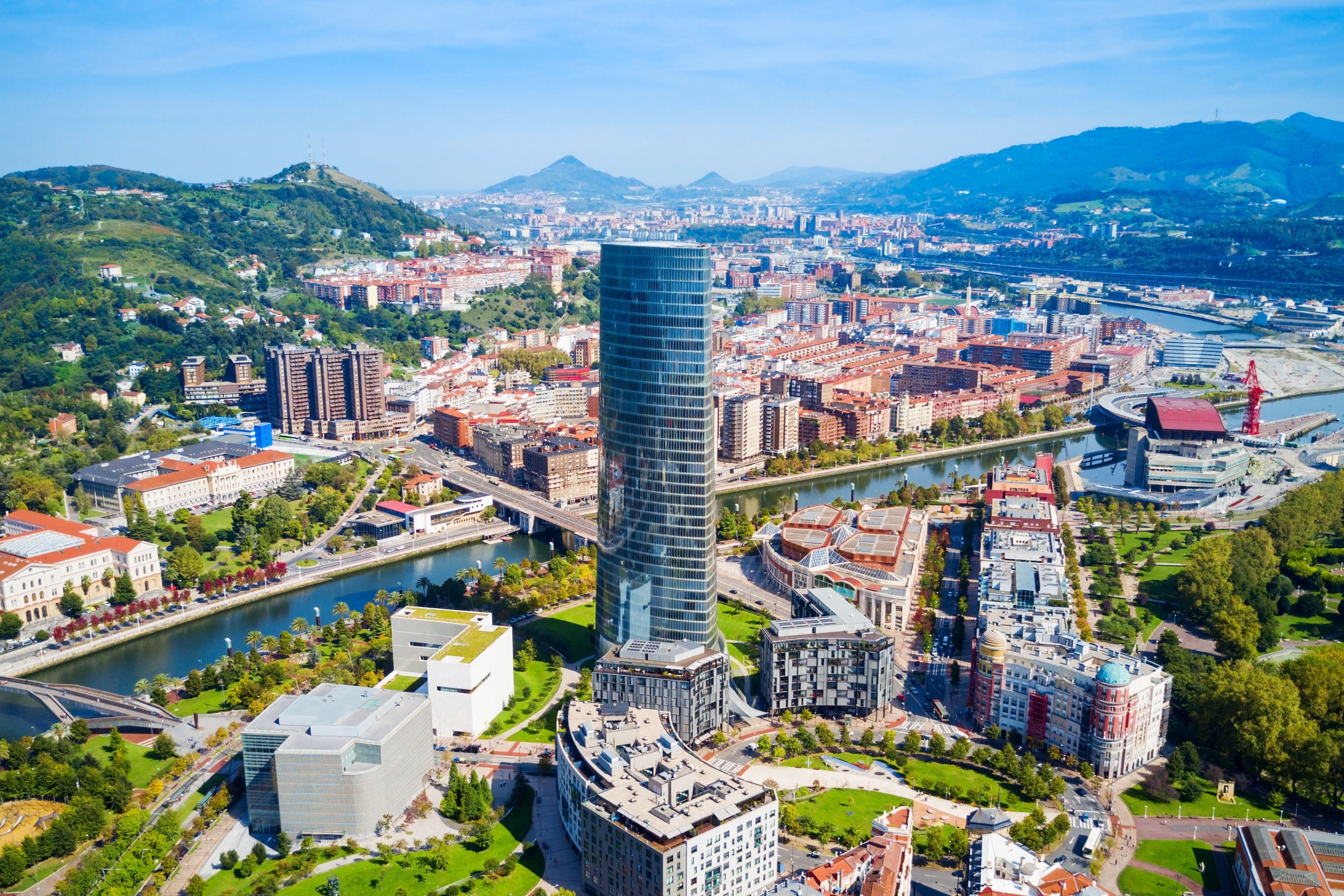 Panoramisk luftfoto af Bilbao med Iberdrola tårnet, floden og bjergene i Baskerlandet, Nordspanien