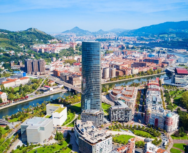 Panoramisk luftfoto af Bilbao med Iberdrola tårnet, floden og bjergene i Baskerlandet, Nordspanien