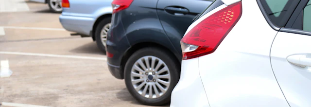Farvede biler parkeret i organiserede rækker på parkeringsplads