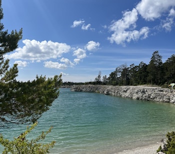 Den betagende Blå Lagune på Gotland med sit krystalklare turkise vand omgivet af lyse sandstrande og grøn vegetation - et naturligt badeparadis ved Sveriges østkyst