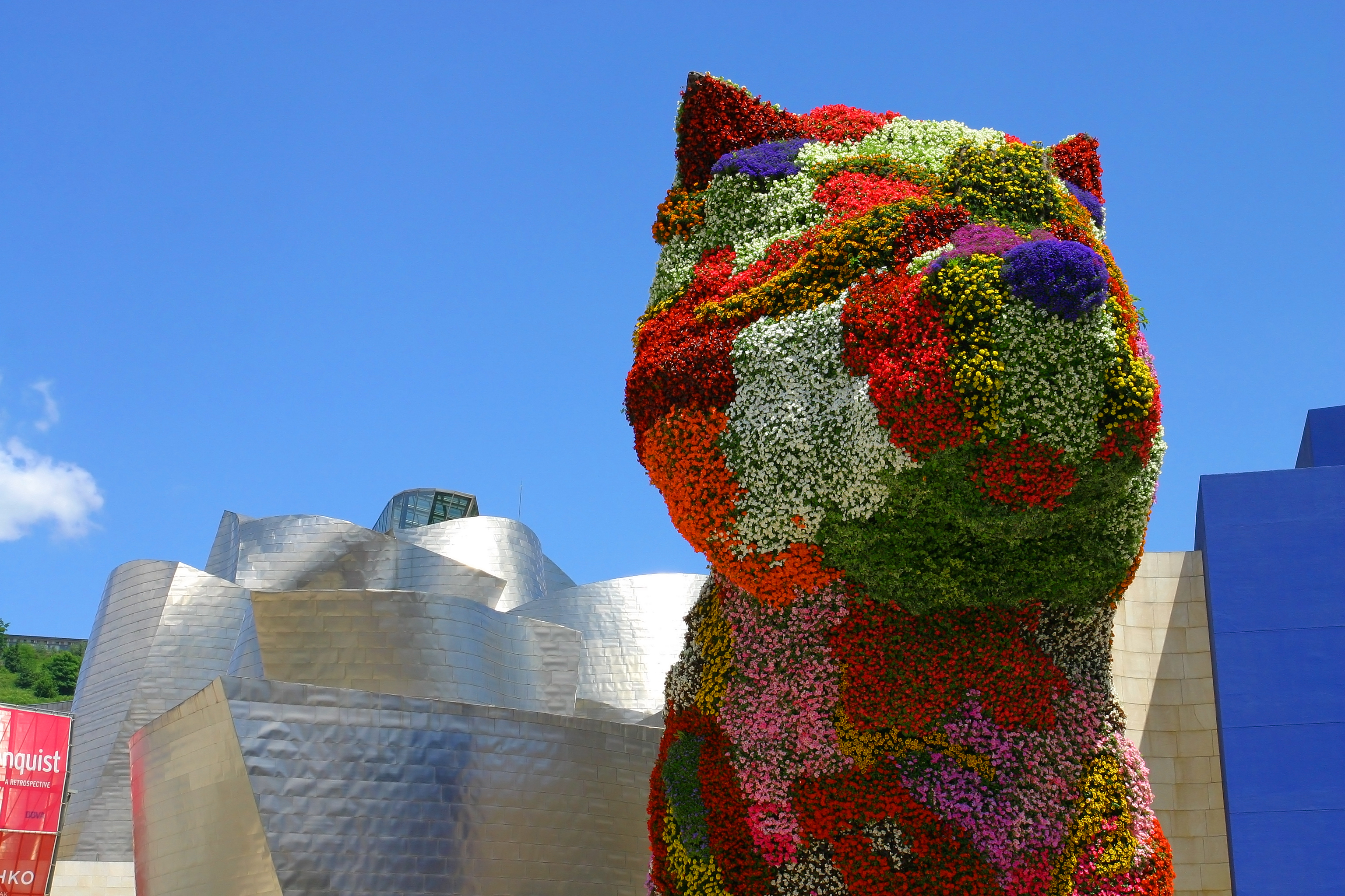 Farverig blomsterhund-skulptur ved Guggenheim-museet i Bilbao, en ikonisk turistattraktion i Spanien