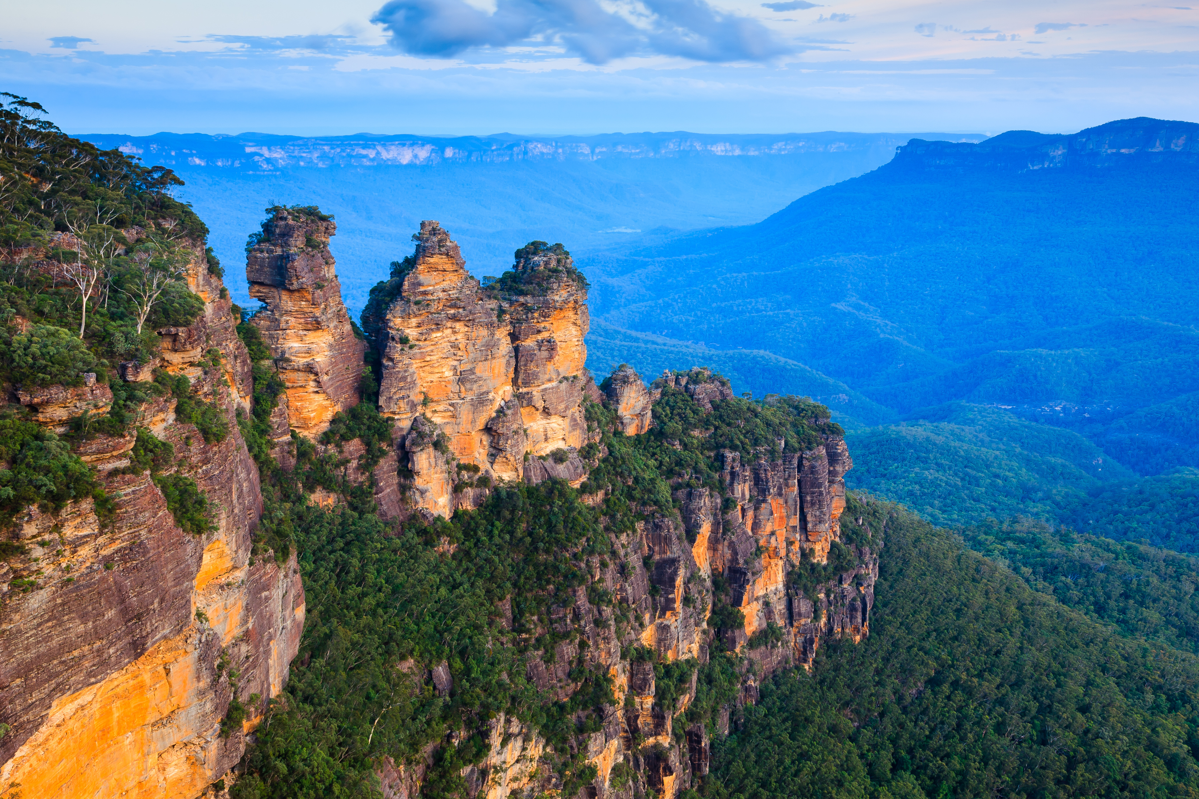 Betagende udsigt over den ikoniske klippeformation The Three Sisters ved Echo Point i Blue Mountains National Park, New South Wales, Australien, badet i gyldent aftenlys ved solnedgang