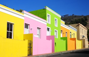 Farvestrålende huse i Bo-Kaap, det historiske malayiske kvarter i Kapstaden, med karakteristiske gule, pink, grønne og blå facader langs gaden