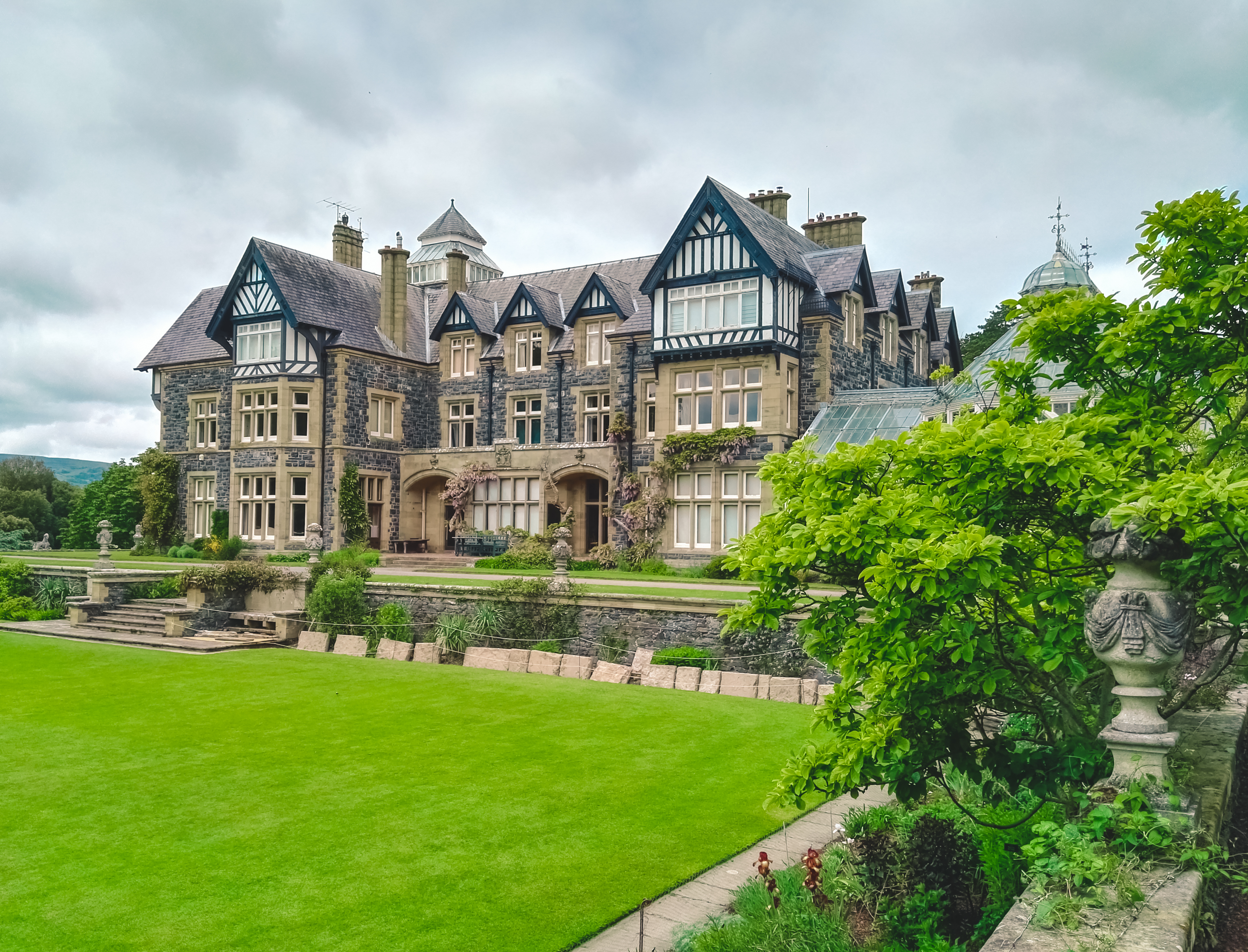 Historiske Bodnant Hall med sine smukke landskabshaver i Nordwales, kendt for frodige plæner og farverige blomsterbede