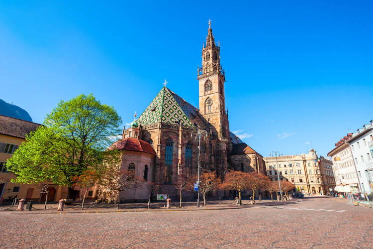 Bolzanos smukke domkirke med det karakteristiske grønne geometriske tegltag og gotisk klokketårn ved Piazza Walther i Sydtyrol, Italien