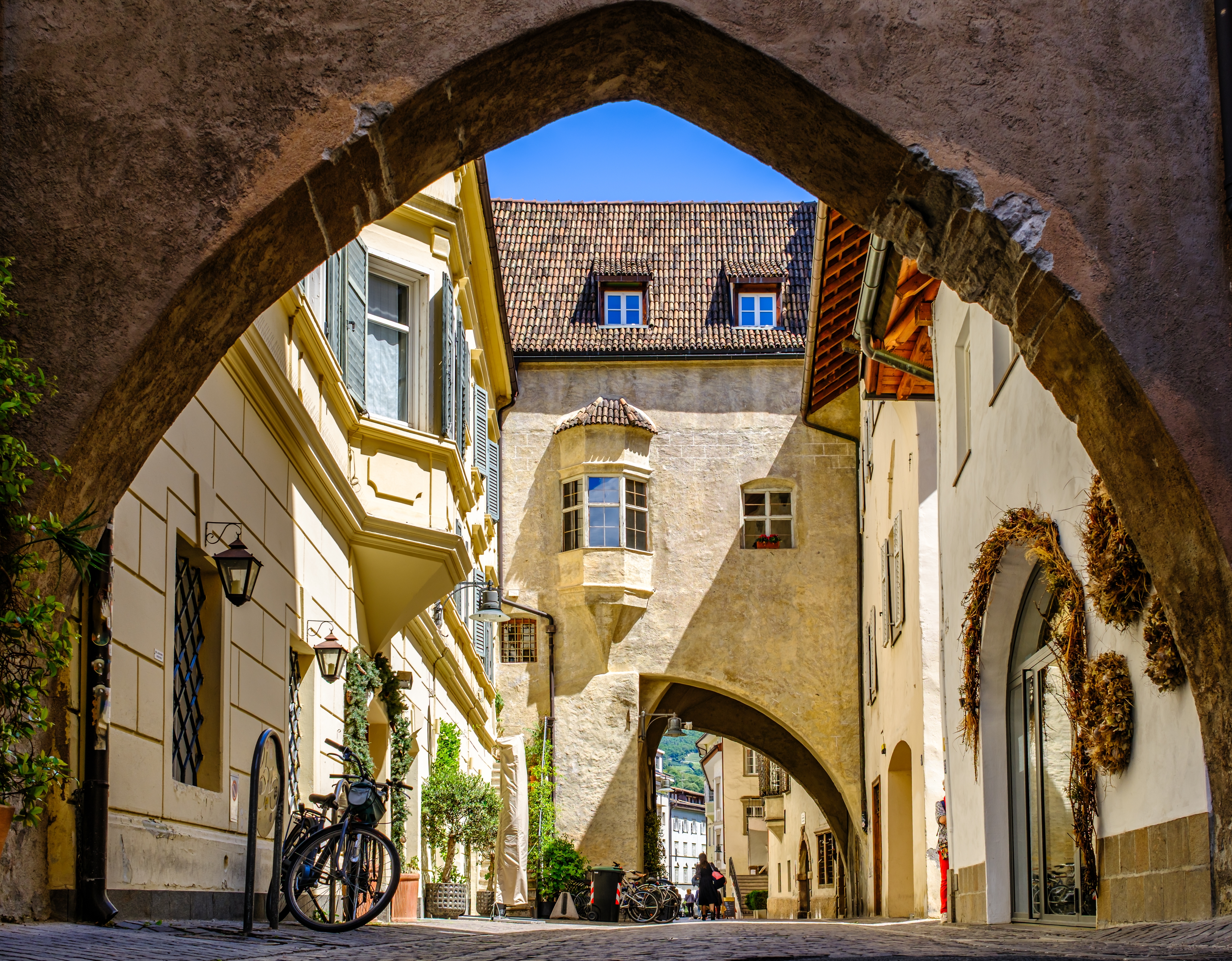 Gotisk stenbue i Bolzanos historiske gamle bydel i Sydtyrol, Italien, med charmerende brolagte gader og traditionel alpin arkitektur