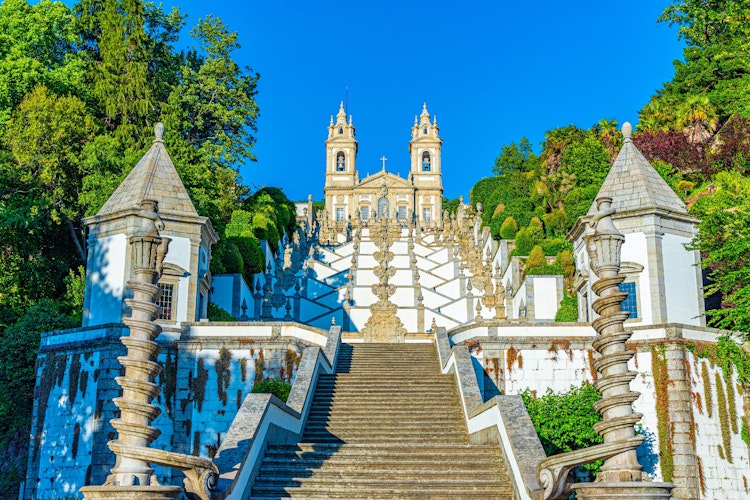 Den berømte barokke trappe til Bom Jesus do Monte helligdom i Braga, Portugal med to tårne omgivet af grøn vegetation