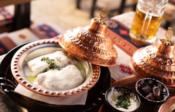 Traditionel bosnisk mad serveret i dekorative kobbergryder i Sarajevo