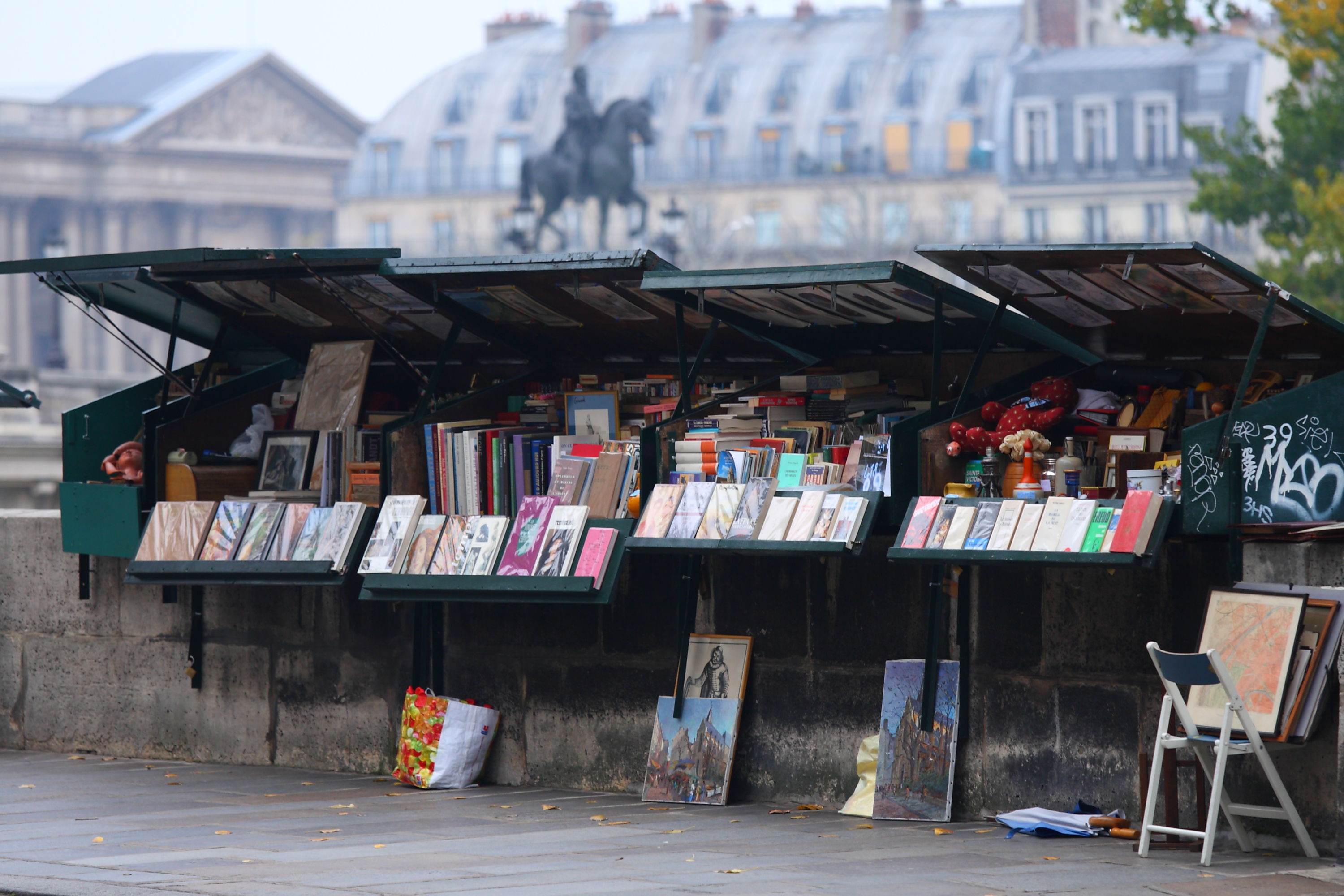 Traditionelle bouquiniste boghandlerstande langs Seinen i Paris med bøger og magasiner udstillet under grønne overdækninger