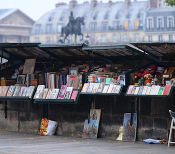 Traditionelle bouquiniste boghandlerstande langs Seinen i Paris med bøger og magasiner udstillet under grønne overdækninger