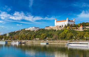 Historisk Bratislava Slot på bakketop med udsigt over Donaufloden og Slovakiets hovedstad på en solrig sommerdag