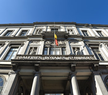Imponerende neoklassisk facade på de historiske Galeries Royales Saint-Hubert i Bruxelles, med elegant stenhuggerarbejde, dekorative søjler og udsmykninger på denne berømte overdækkede shoppingarkade fra 1800-tallet
