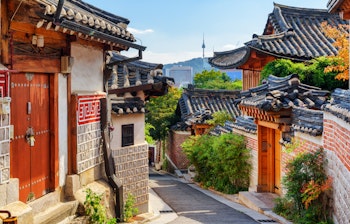 Charmerende udsigt over traditionelle koreanske huse i Bukchon Hanok landsbyen med Seoultårnet på Namsan-bjerget i baggrunden