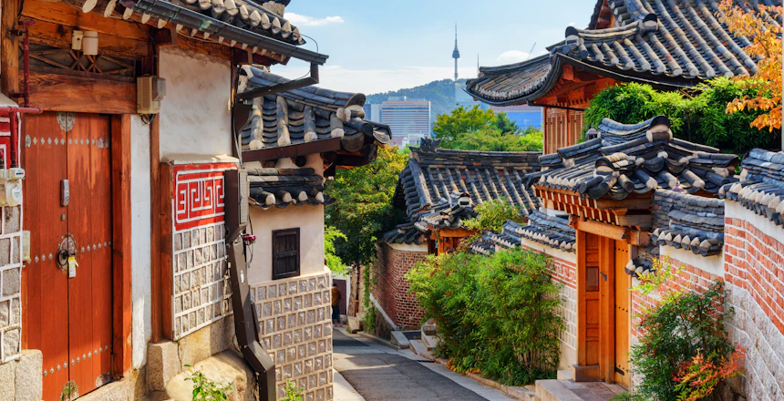 Charmerende udsigt over traditionelle koreanske huse i Bukchon Hanok landsbyen med Seoultårnet på Namsan-bjerget i baggrunden