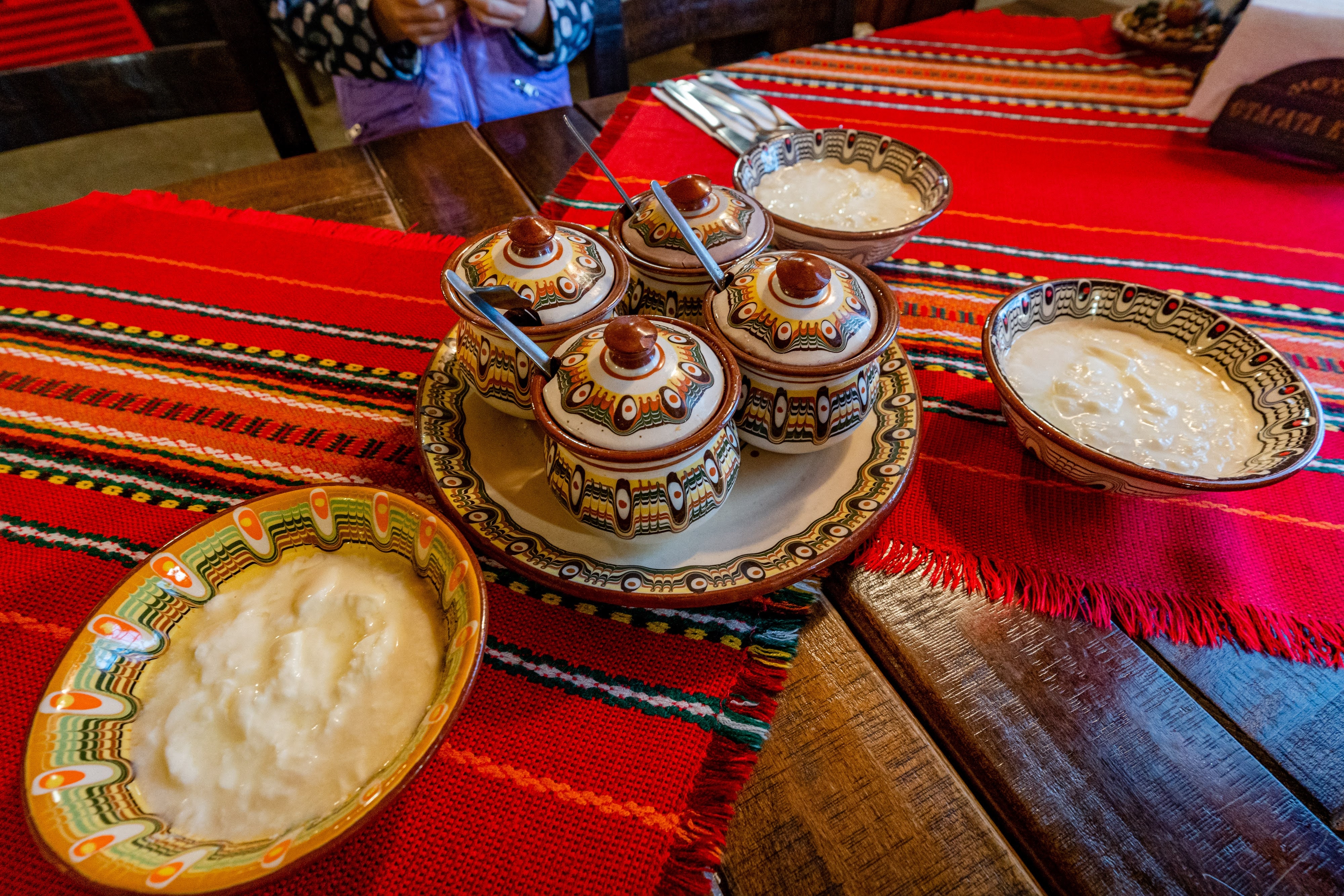 Traditionel bulgansk morgenmad med hjemmelavet yoghurt og syltetøj serveret i håndlavede keramikskåle