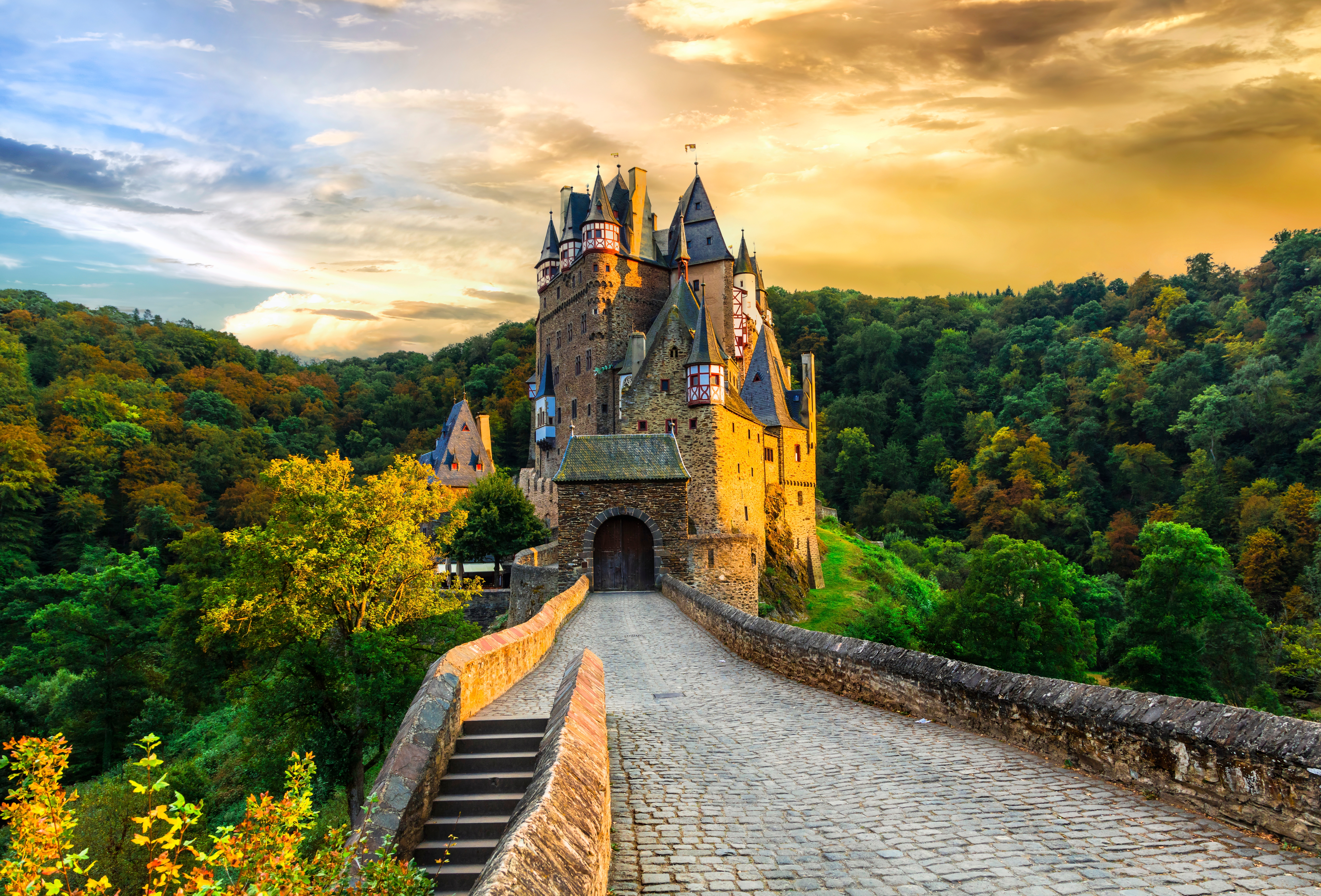 Det romantiske middelalderslot Burg Eltz omgivet af efterårsfarver ved solnedgang i Rhinland-Pfalz, et af Tysklands mest bevarede og ikoniske slotte