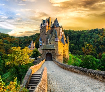 Det romantiske middelalderslot Burg Eltz omgivet af efterårsfarver ved solnedgang i Rhinland-Pfalz, et af Tysklands mest bevarede og ikoniske slotte