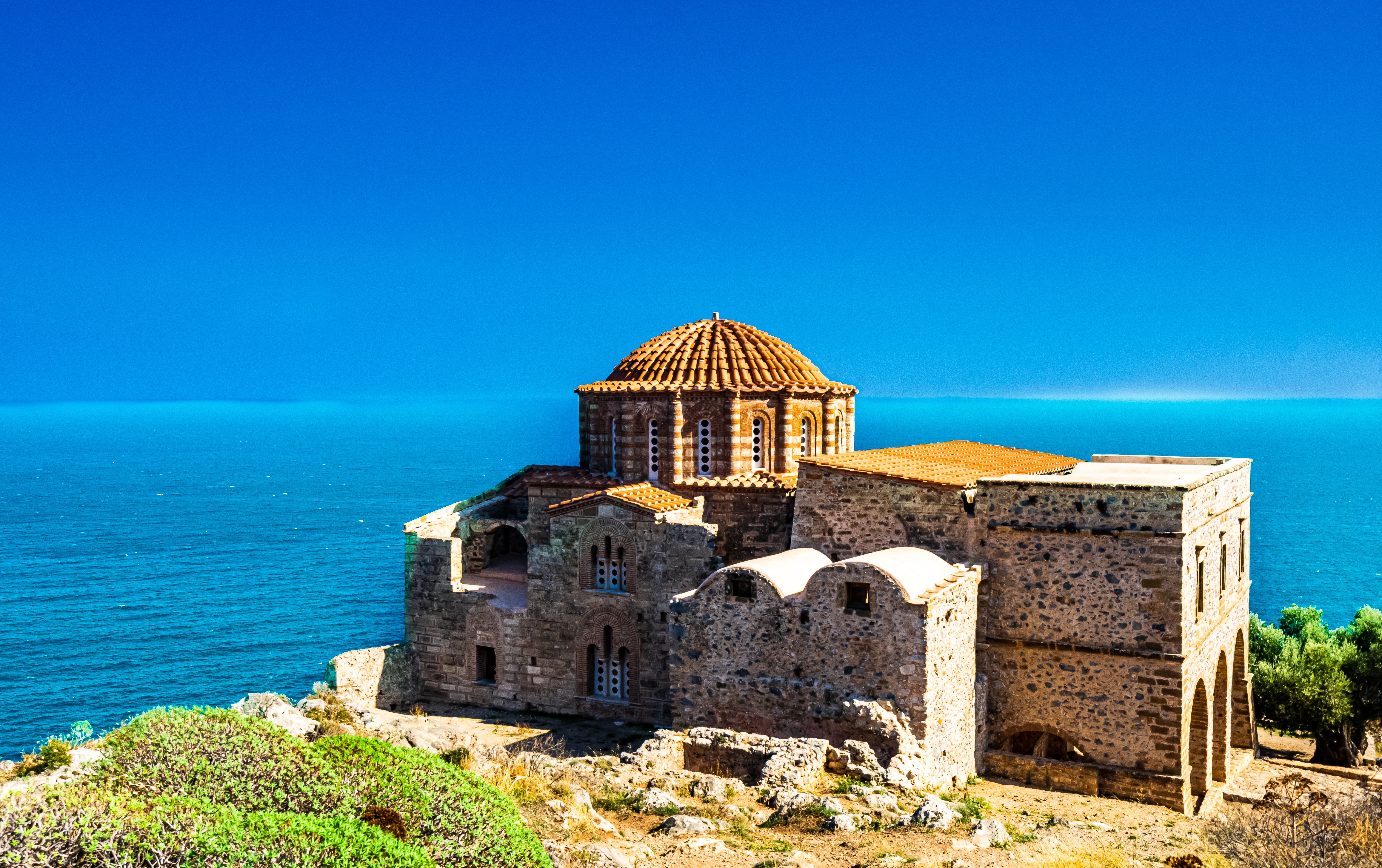 Den historiske byzantinske Panagia Odigitria-kirke med udsigt over Middelhavet i middelalderlige Monemvasia, Peloponnes, Grækenland