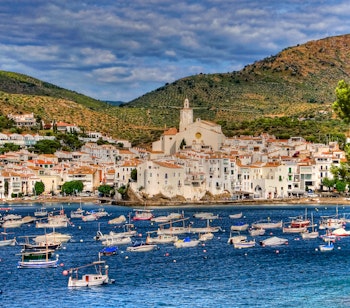 Idylliske Cadaqués med sine karakteristiske hvide bygninger og fiskerbåde ved Middelhavets azurblå vand i det østlige Catalonien nær den franske grænse