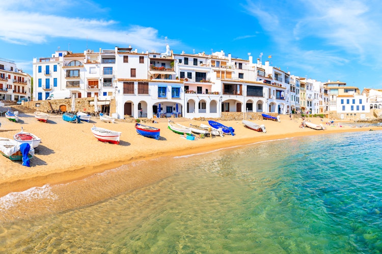 Malerisk udsigt over farverige huse og fiskerbåde på stranden i Calella de Palafrugell, Costa Brava, Spanien