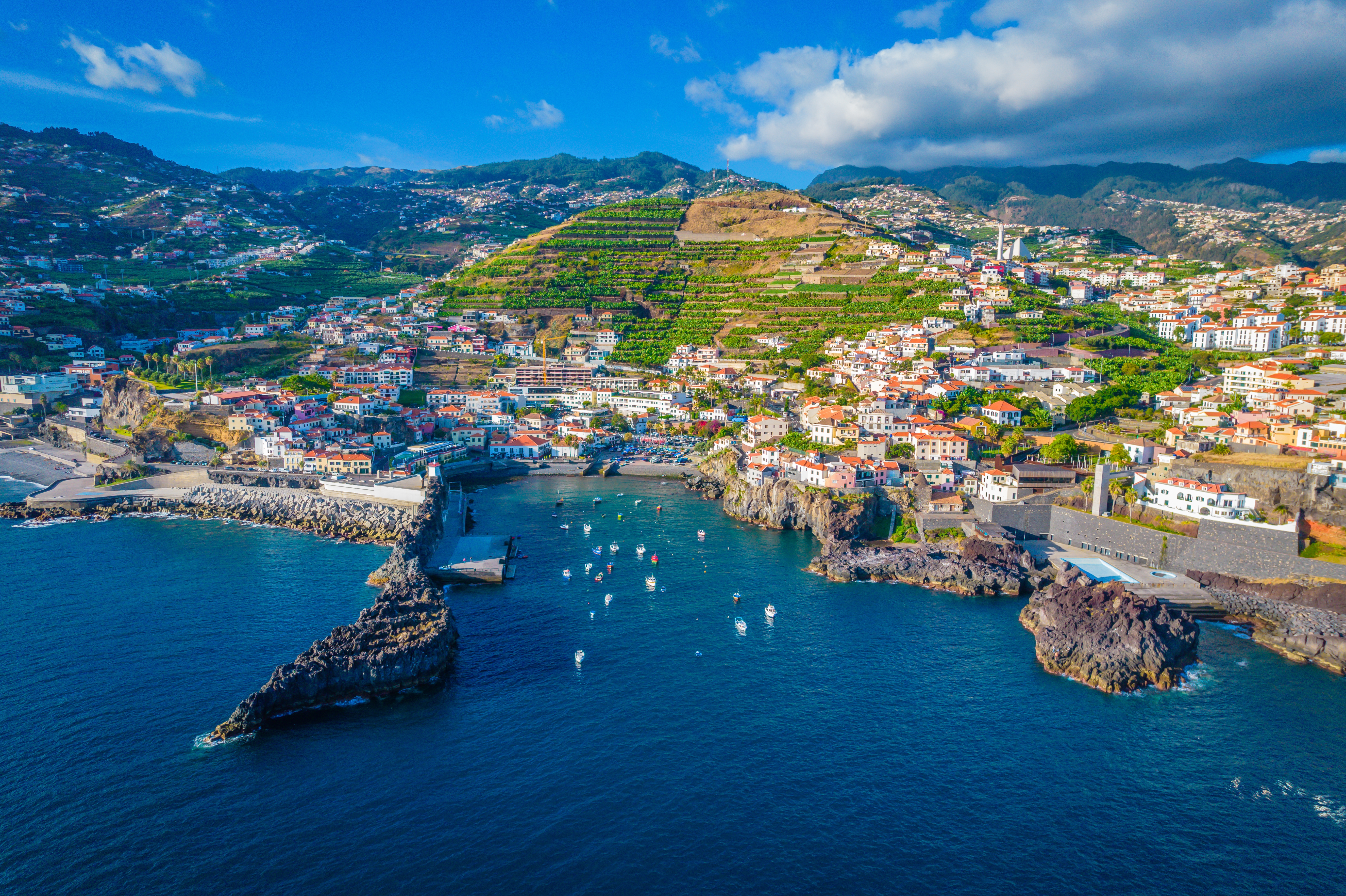 Luftfoto af den charmerende fiskerby Câmara de Lobos nær Funchal på Madeira med farverige huse og både i havnen