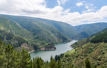 Naturskøn udsigt over flodlandskab langs pilgrimsruten Camino de Santiago i Nordspanien med bjerge og grønne skove