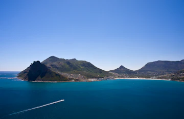 Betagende udsigt over Camps Bay kysten i Cape Town med turkisblåt hav og majestætiske bjerge i baggrunden
