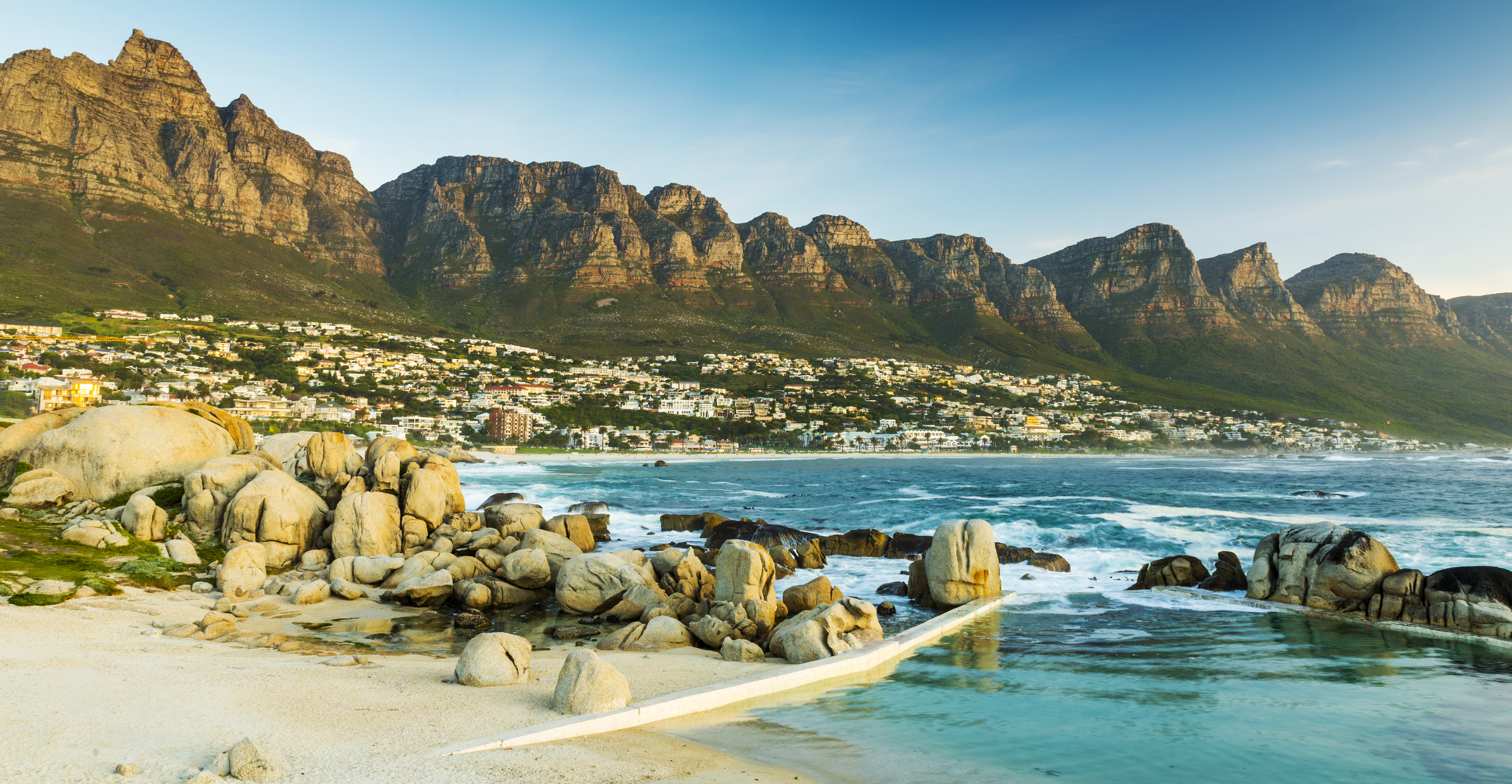 Smuk solnedgang over Camps Bay strand med Table Mountain i Cape Town, Sydafrika