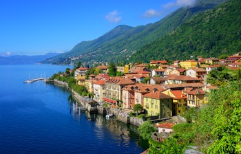 Idyllisk udsigt over den historiske ferieresort Cannero Riviera med farverige bygninger ved Lago Maggiore søen omgivet af Alperne i Norditalien