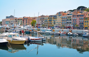 Malerisk udsigt over den gamle havn i Cannes med farverige bygninger og lystbåde ved Den Franske Riviera