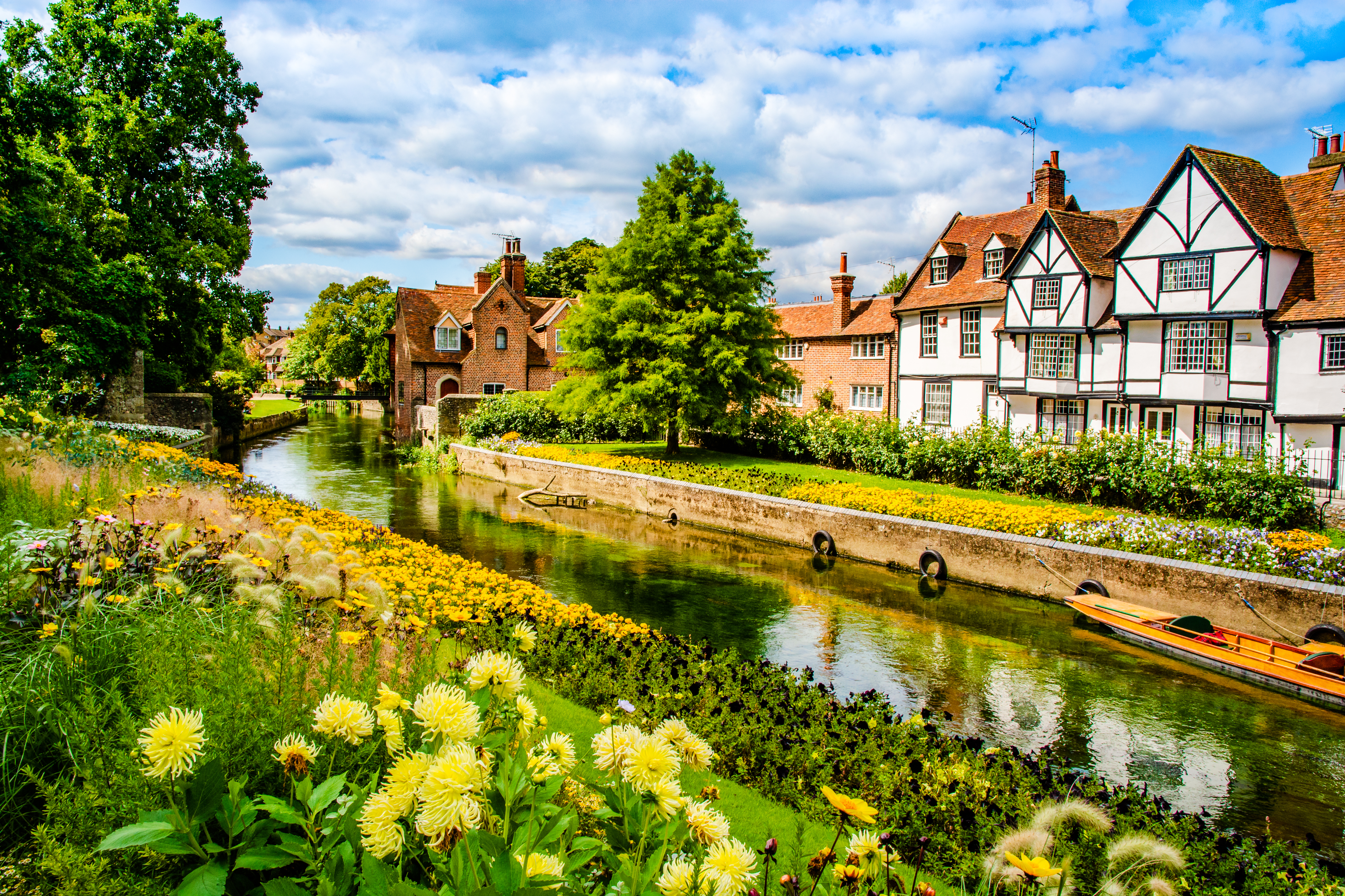 Smuk udsigt over floden Great Stour i Canterbury med farverige sommerblomster og historiske Tudor-bindingsværkshuse ved Westgate Gardens i Kent, England