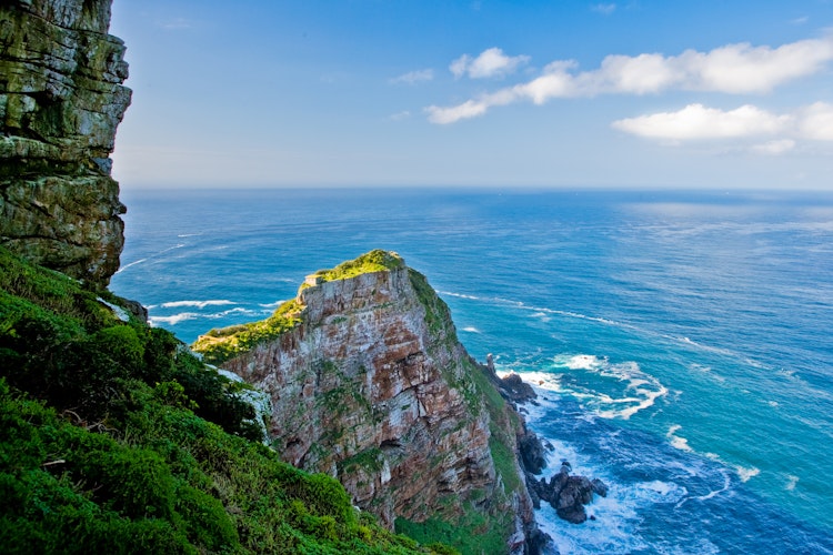 Betagende udsigt fra Cape of Good Hope i Sydafrika med dramatiske klipper og det turkisblå Atlanterhav i horisonten