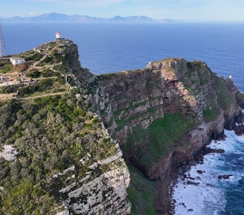 Det ikoniske Cape Point fyrtårn tronende på de dramatiske klipper i Table Mountain National Park, hvor to oceaner mødes ved Sydafrikas sydligste spids