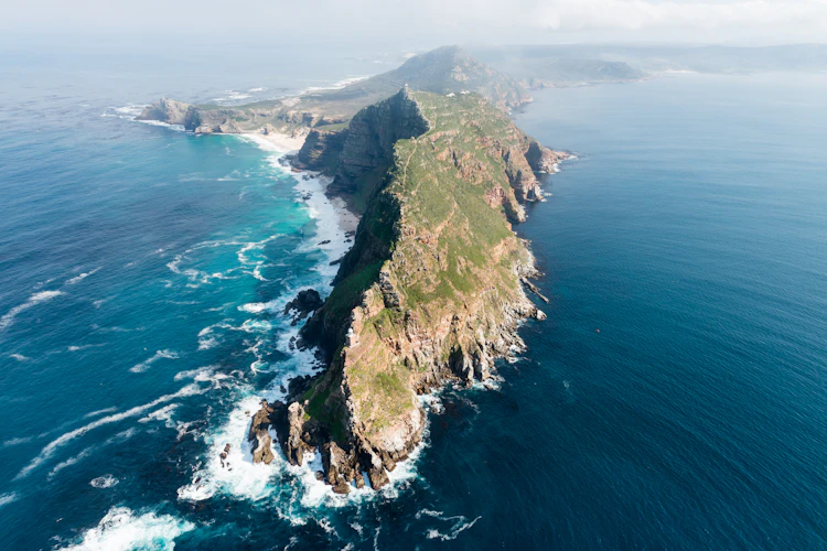 Spektakulært luftfoto af Cape Point med dramatiske klipper og turkisblåt ocean i Sydafrika