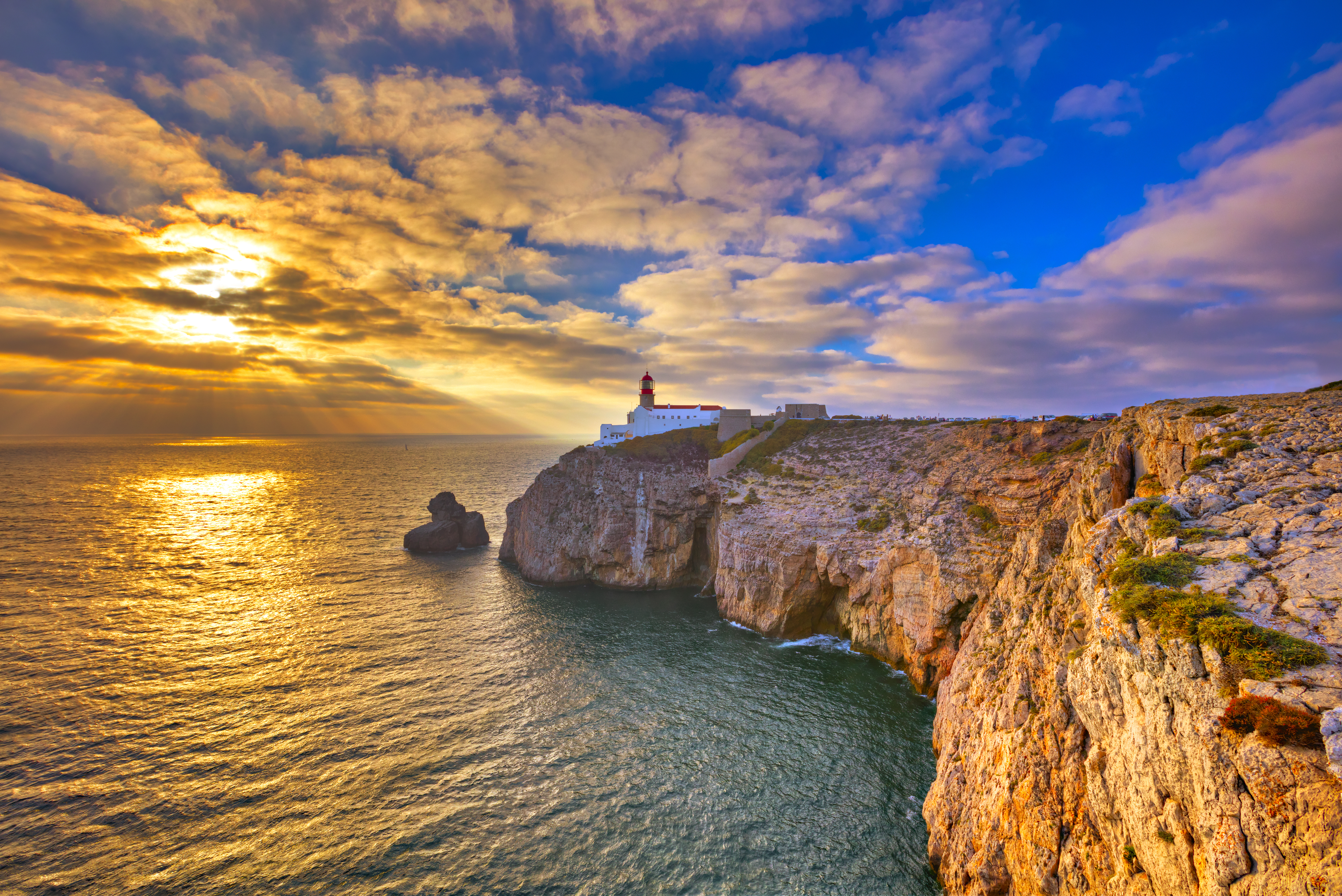 Solnedgang ved Cape St. Vincent fyrtårn og dramatiske klipper i Portugal