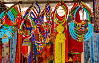 Farvestrålende udvalg af traditionelle afrikanske perle- og håndlavet smykker på et lokalt marked i Cape Town, Sydafrika