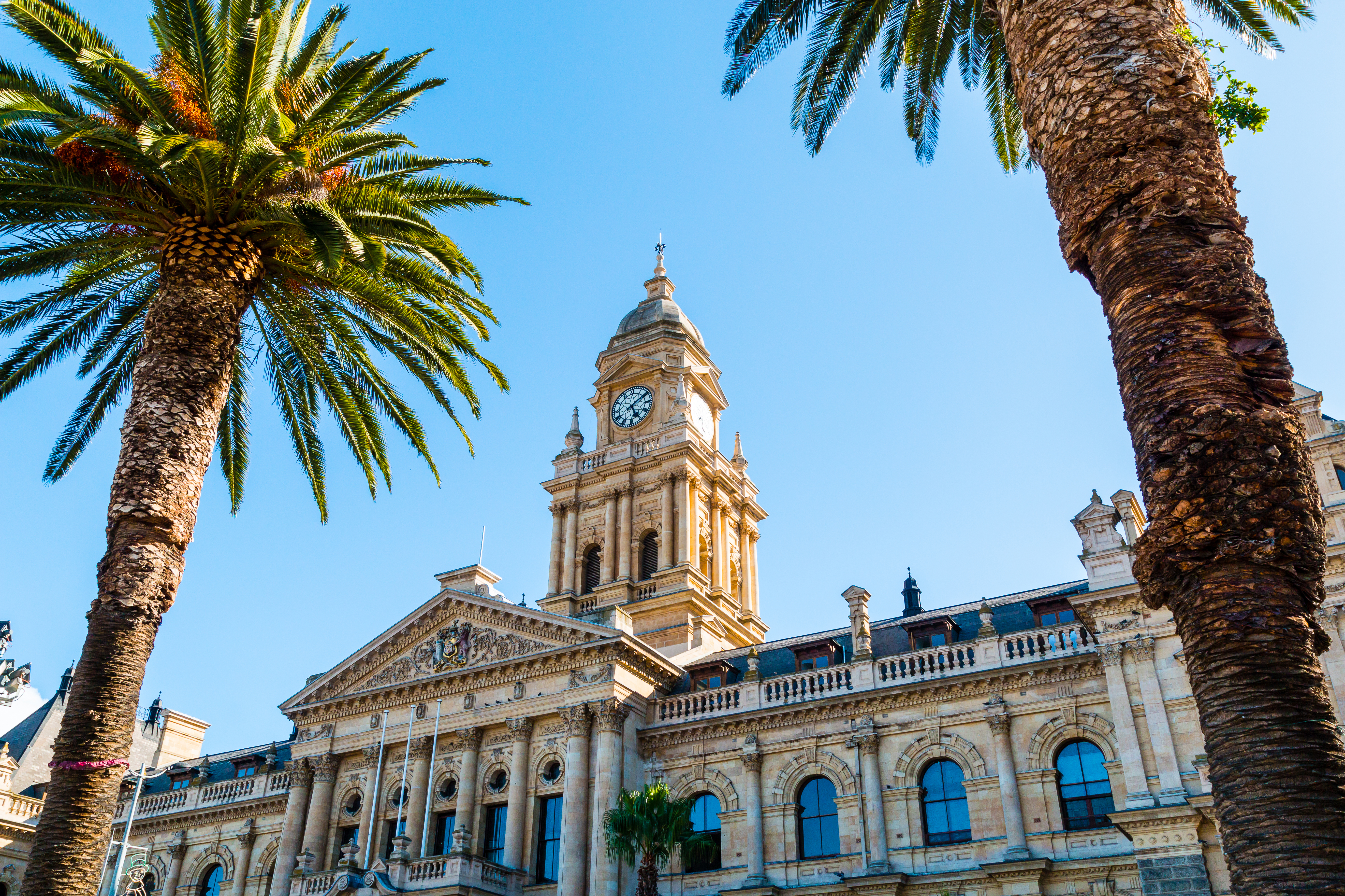 Det historiske rådhus i Cape Town med sin imponerende Edwardianske kalkstens-facade og markante klokketårn mod en blå himmel i Sydafrika